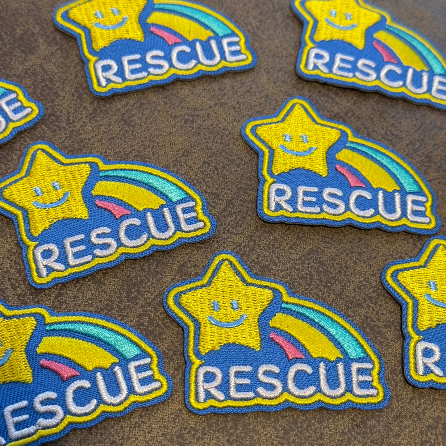 Star-shaped patches with 'RESCUE' text on a brown background