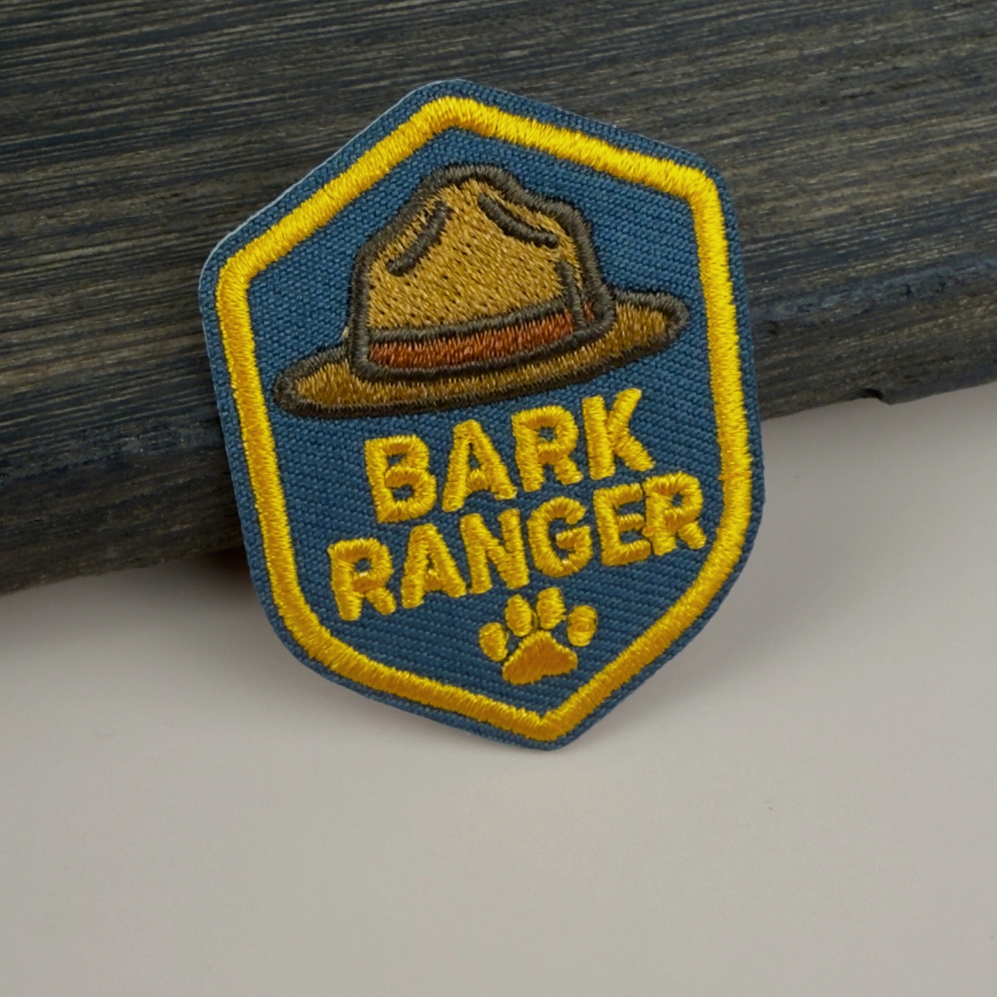 Patch with 'Bark Ranger' text and a ranger hat design on a wooden surface