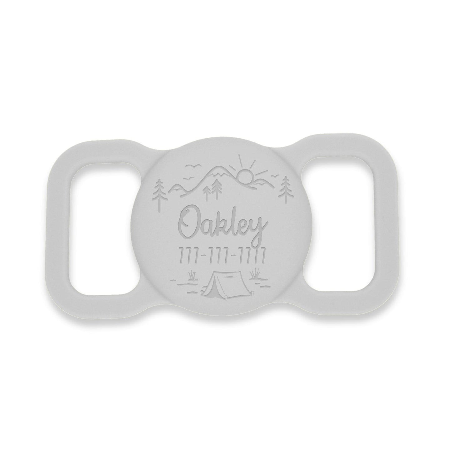 Grey silicone AirTag holder with an outdoors landscape design, featuring a mountain with a sunrise. Pet's name and phone # are custom engraved.