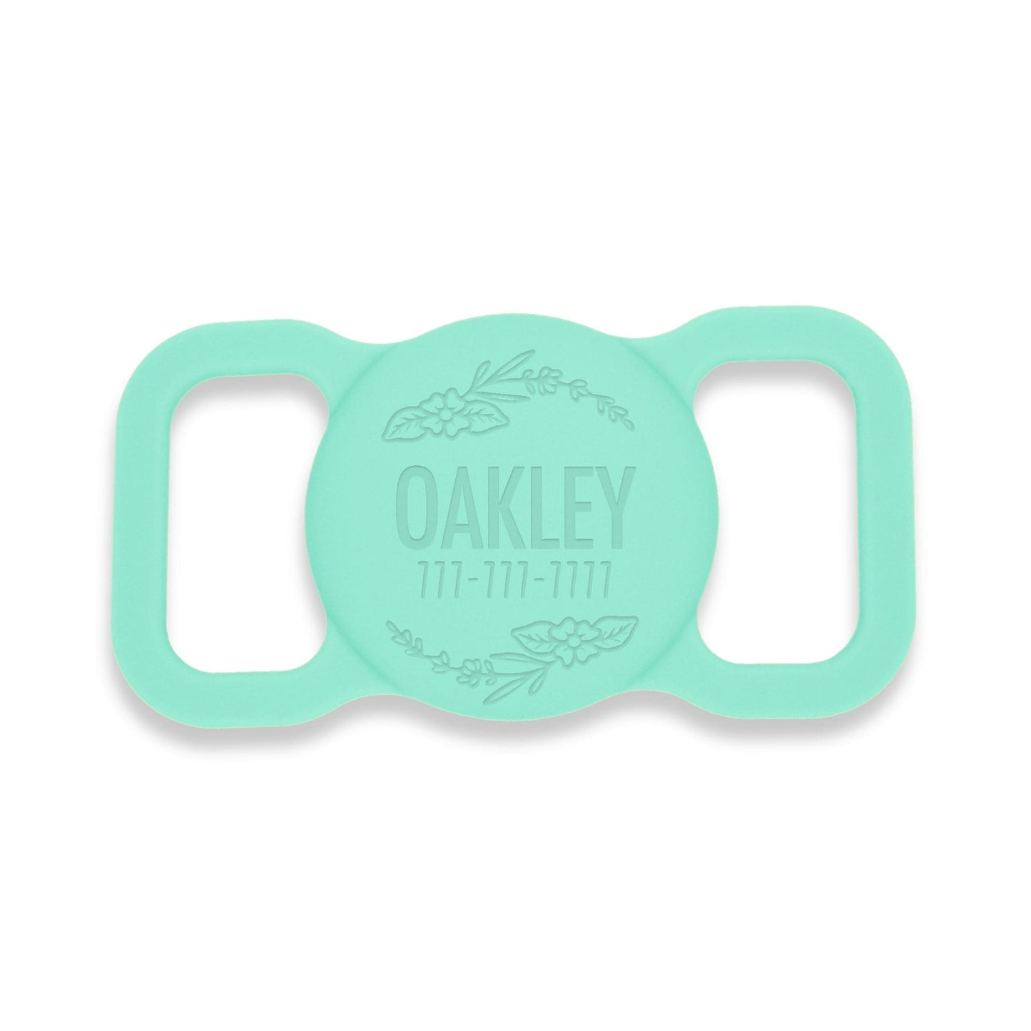 Aqua silicone AirTag holder with a floral design. Pet's name and a phone # is engraved on the front.
