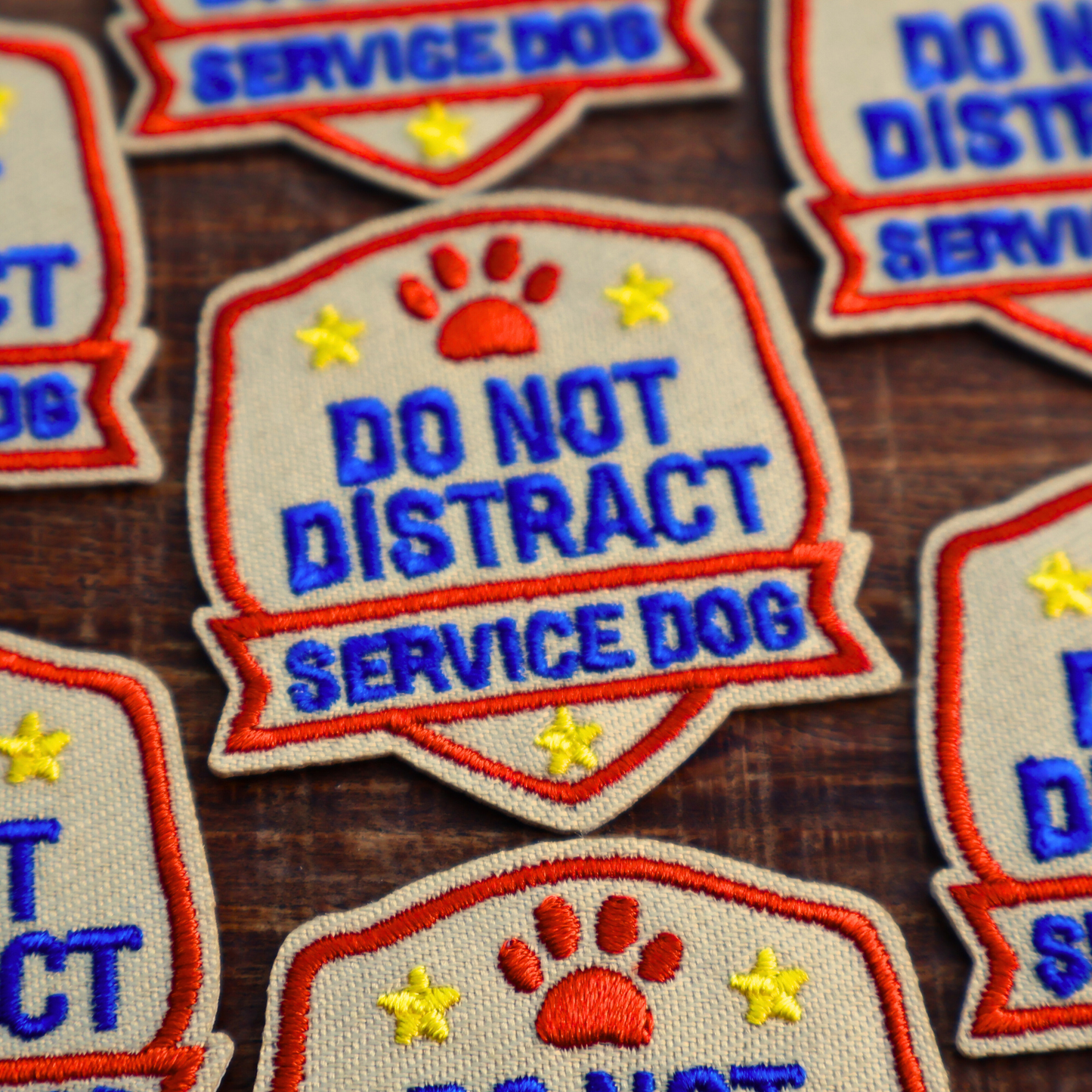 Service dog patches with 'Do Not Distract Service Dog' text on a wooden surface