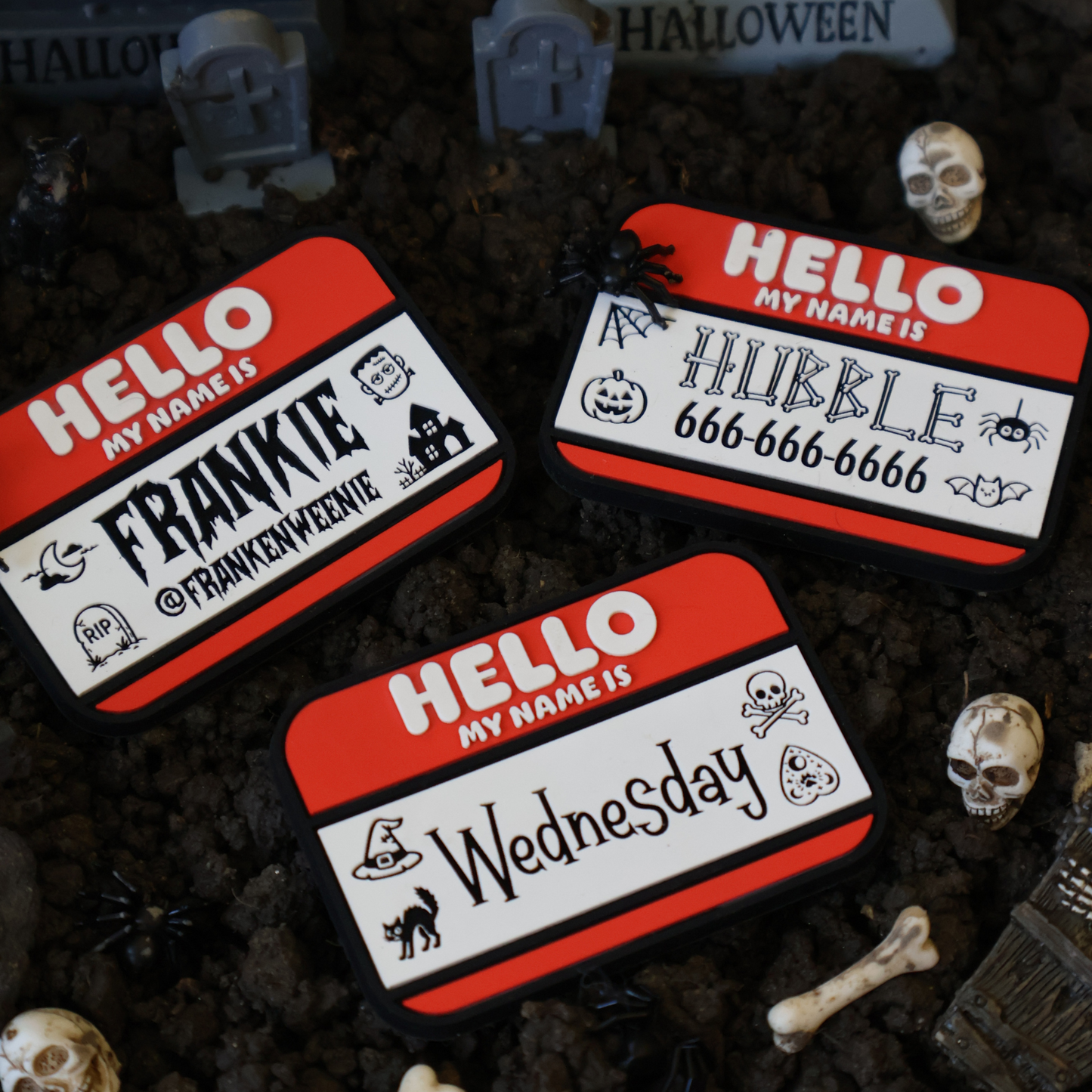 Three pet ID name tags with Halloween-themed names on a dark background with tombstones and skulls.