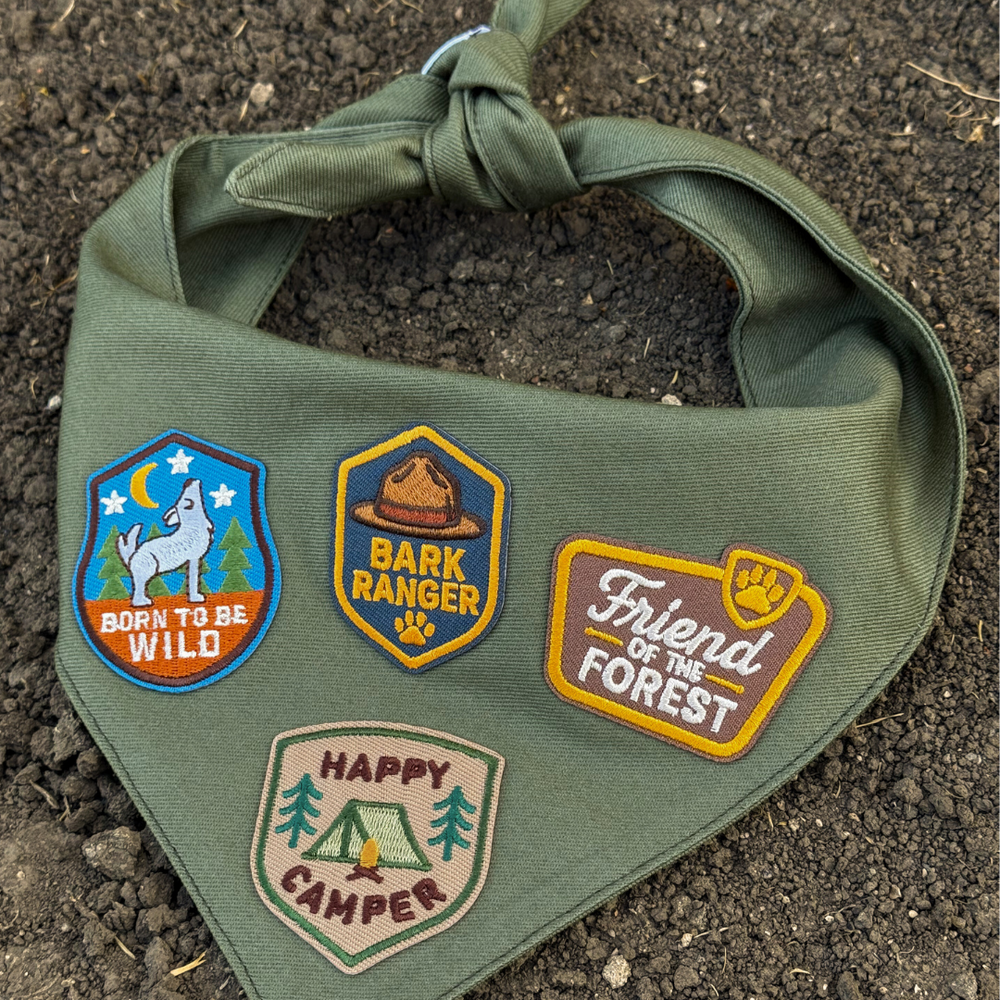 
                  
                    Green bandana with nature-themed patches on a dirt background
                  
                