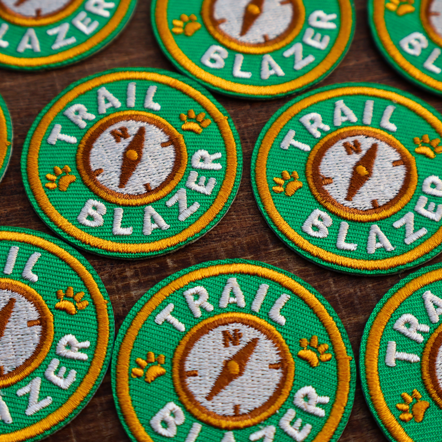 Multiple 'Trail Blazer' patches on a wooden surface