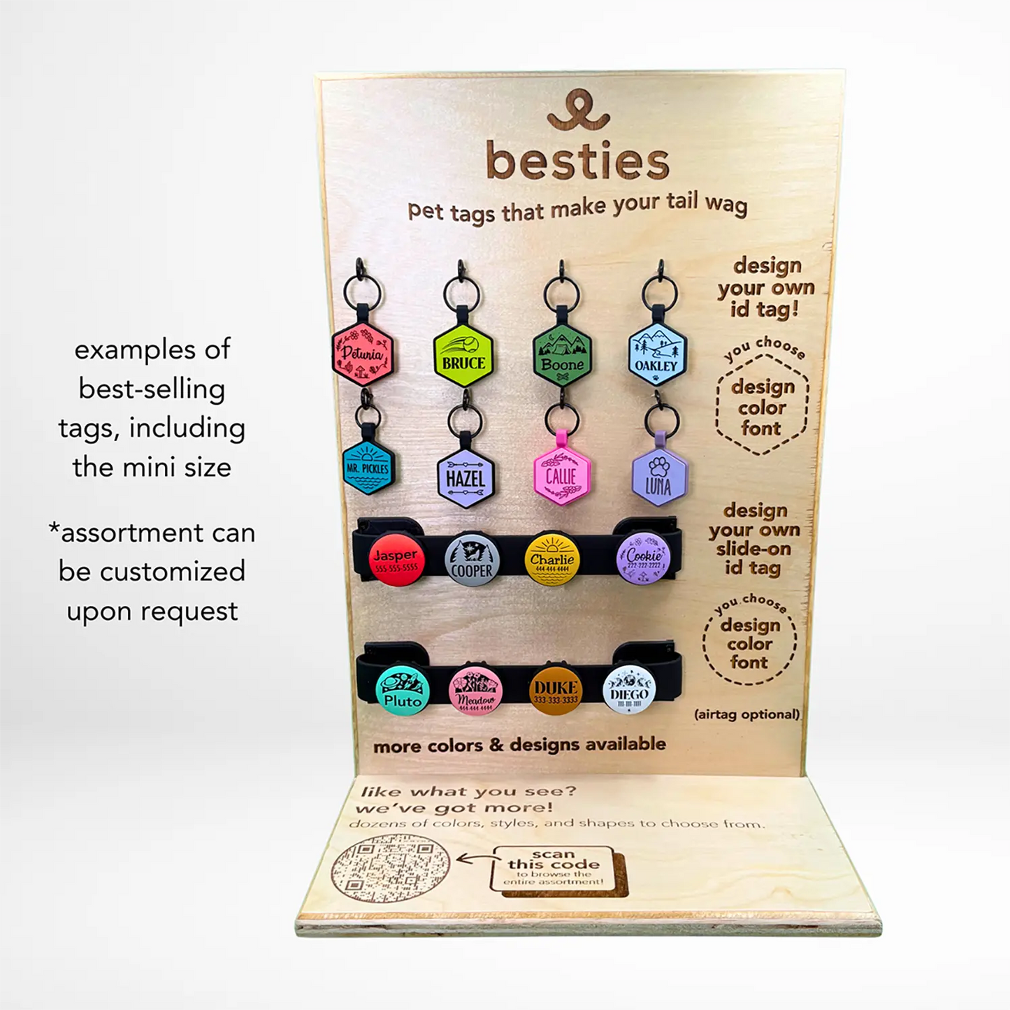 Display of silicone pet ID tags with 'besties' branding on a wooden stand.