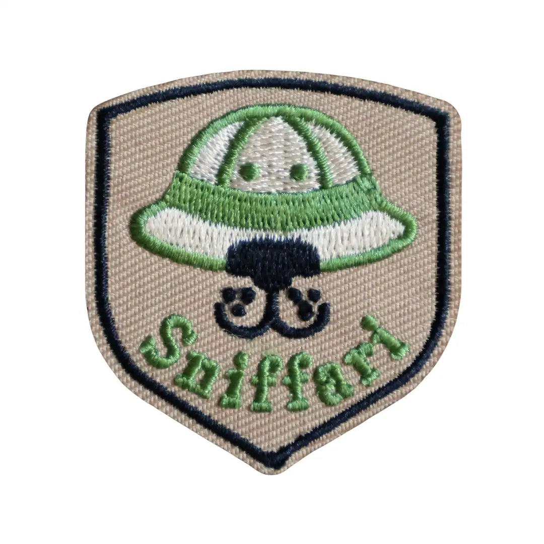 Iron-on patch with a green and white hat design on a beige background that says "Sniffari"